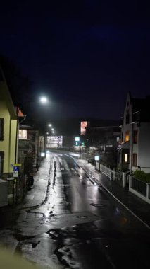 Gece şehir ambiyansı, sessiz şehir sokağı, sakin ama gergin şehir manzarası gece atmosferinde, atmosferik bir şehir caddesi neon ışıkları ve yansıtıcı yüzeylerle aydınlatılıyor.