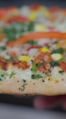 Taze malzemelerle süslenmiş ve pişirmeye hazır lezzetli bir sebzeli pizzayı yakından çek. Ağır çekim. Yüksek kalite 4k görüntü