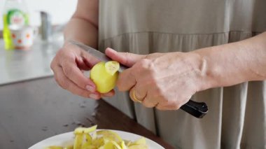 Mutfak patatesi hazırlama, ev yapımı patates soyma, patates soyma, patates soyma sahnesi, patates püresi hazırlayan insan, doğal ışıklandırma ve buruşuk eller.