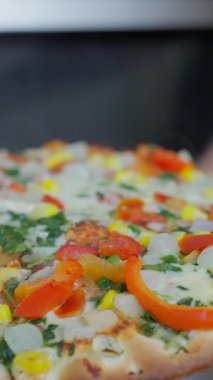 Taze malzemelerle süslenmiş ve pişirmeye hazır lezzetli bir sebzeli pizzayı yakından çek. Ağır çekim. Yüksek kalite 4k görüntü