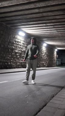 Gece koşucusunun alt geçidi. Boş beton tünellerde yürür. Lambalarla aydınlatılır. Kapüşonlu ve yansıtıcı kaldırımlı yavaş tempolu eğitim.