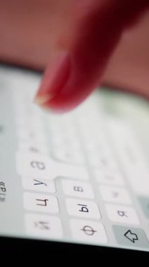 Aygıt üzerinde hızlı başparmak hareketi, ekranda Kiril harflerini hızla yazan parmakları kapatma, modern iletişim bağlamında hızlı başparmak ve parmak hareketleri yakalayan odaklanmış resim