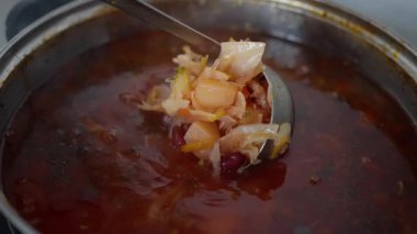 Canlı, lezzetli bir çorba tenceresi taze malzemelerle yavaşça kaynıyor, gerçek mutfak sanatını sergiliyor. Ukrayna yemeği çorbası pişiriyorum. Ağır çekim. Yüksek kalite 4k görüntü