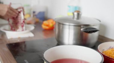 Kâseye nar tohumları sıkıştırmak, meyvelerden toplanan kırmızı meyve suyu, pişirme kabının yanındaki tabağın üzerine tohum sıkıştırmak, mutfak tezgahındaki nar tohumlarından elde edilen canlı kırmızı sıvı.