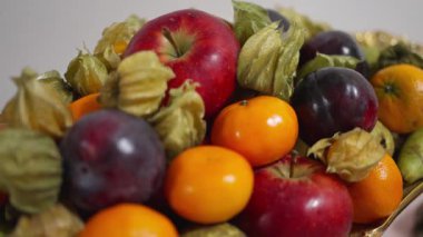 Şatafatlı meyve süsü karışık elmalar, parlak erikler, altın filozof ve canlı narenciye, ziyafet ve konukseverlik için tasarlanmış, yumuşak yönlü ışık