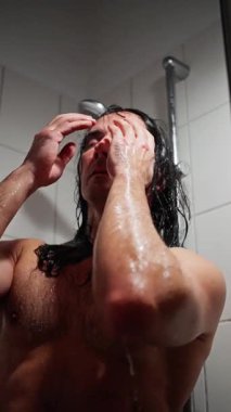 Duşta saçını yıkayan adam, banyoda saçını yıkayan düşünceli yüzlü adam beyaz adam, duş alırken saçlarını dikkatlice yıkayan adam.