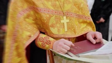 Rahibin elleri açık dua kitabında, işlemeli altın yelek kolunda görünür, Yavaş Sayfa Çevirimi ve Yumuşak Odaklı Kilise İçi, Edebiyat Dönemi Saygıdeğer Atmosfer, Parmaklar Sakin