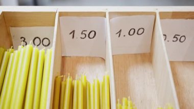 Etiketli ahşap rafta fiyatlı sarı şerit mumlar, sayılı kompartımanlarda, butik sayaç sahnesinde el yazması fiyat etiketleri gösteriliyor. - Evet. - Evet. ., Stok Çeşitliliği ve Boyut Karşılaştırması