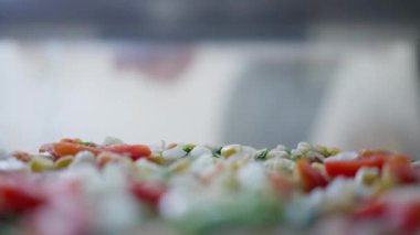 Tezgahta taze sebzeli pilav, rengarenk domates ve havuçlu sığ alan derinliği, saçılmış pirinç taneleri ve otlar, yumuşak doğal ışık ve hafif İştah açıcı Bokeh