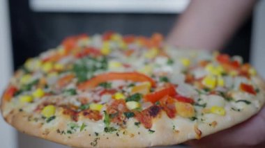 Palm Closeup 'ta El Yapımı Sebze Pizzası Çıtır Çıtır Bitki Kabuğu, Eritilmiş Peynir, Kızarmış Biber Dilimleri, Mısır Gevreği ve Taze Fesleğen, Şefin Elle Verdiği Turta Bulanık Mutfak Arkaplanmasına Karşı, Sıcak