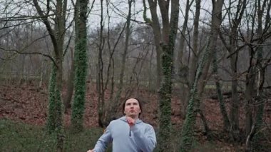 Cesurca Bireysel Gösteriler Çeviklik Yeteneği, Kişi Doğal Ayarlarda Etkileyici Havada Tekme Gösteriyor, Sporcu Doğada Çevrede Olağanüstü Havadan Bölünme Tekmesi Gösteriyor