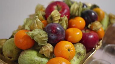 Mandalina, erik, elma, armut ve kağıt kabuklarıyla süslü altın tepsi stüdyoları sığ ses tonlarıyla sığ meyve tabakları sergilenen canlı taze meyve düzenlemeleri.,