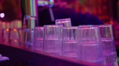 Neon Yansımalar Aydınlatıcı Fincanlar, Neon Işıkları Yansıtan Şeffaf Bardaklar, Neon Işıkları Yansıtan Plastik Bardakların Yakın Çekimi Neon Işıkları Hızlı İçkiye Hazır