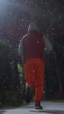 Kış Gecesi boyunca huzur içinde koşmak. Adam Karlı Park Patikası boyunca sakince koşuyor. Huzurlu bir akşam saatinde Karlı Park 'ta koşarken İstikrarlı Yürüyen Bir Şahıs