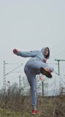 Bireysel Dövüş Sanatları Tekmesi Dışarıya. Doğal ortamdaki Fullextension Dövüş Tekmesi 'ni yapan kişi. İnsan Eğitimleri Kusursuz Dövüş Sanatları Bulutlu Gökyüzünün Altındaki Çayırda Tekmelendi