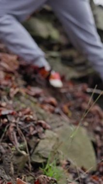 Kaygan kayanın üzerinde duruyor. Islak Taş yüzeyinde dikkatle dengeleniyor. Sonbahar sezonu boyunca Kaygan Doğal Arazide Kusursuz Ayak ve Elle Yerleştirme Egzersizleri