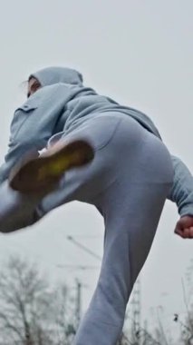 Adam Dövüş antrenmanı yapıyor. Bulutlu Gökyüzü Altında Çarpıcı ve Savunma Tatbikatları Yapan Adam. Erkek Performans Eğitim Çalışmaları Doğal Çevrede Çarpıcı ve Koruma Tekniklerini Vurguluyor