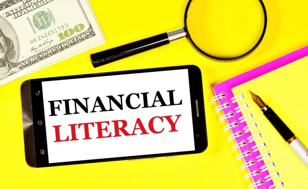 Financial literacy. Text label on the screen of your smartphone. Learning the skills to make smart decisions in a successful business strategy.