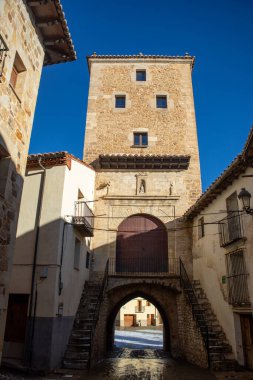 Karlı ve güneşli bir günde, Mosqueruela, Teruel, Aragon Özerk Topluluğu 'nun arka tarafından Portal de San Roque' un dikey görüntüsü