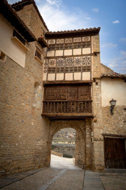 Ortaçağ duvarında süslü ahşap balkonuyla rahibe Mirambel, Teruel, Aragon, İspanya geçidi.