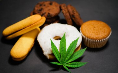 Cannabis food. CBD oil. Marijuana edibles. Medical use. Black background clipart