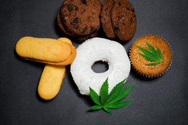 Cannabis food. CBD oil sweets. Marijuana edibles. Medical use. Black background. Top view  clipart