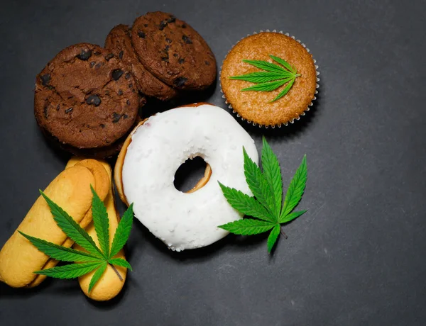 Cannabis food banner. CBD oil sweets donut, cake, cookies. Marijuana edibles. Medical use. Black background. Top view