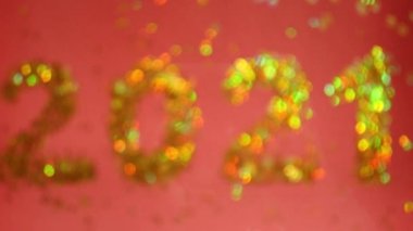 2021 altın sayı bulanık. 4K video. Parlayan yıldızlar. Kırmızı arka plan. Yeni yıl kutlaması 