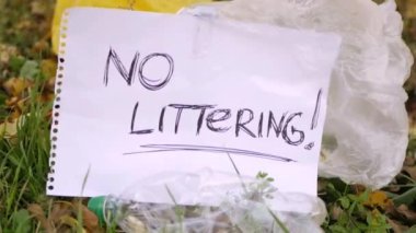 Plastik çöp ve polietilen poşetlerle çevrili parkta çöp işareti yok. Sesli 4K video. İklim değişikliği konsepti. Çevre koruma. Gezegenle ilgilenin. 