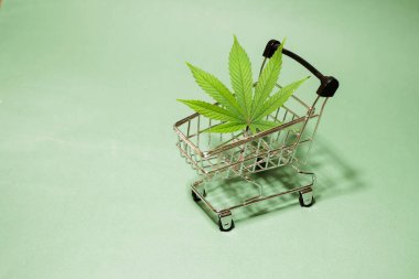 Alışveriş arabası afişinde kenevir yaprağı. Tıbbi ot. Hızlı marihuana teslimatı. Boşluğu kopyala. 
