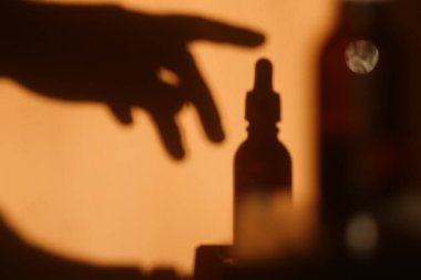El silueti Düşüren Şişe 'yi kaldırıyor. Kozmetik marka konsepti. Cbd yağı