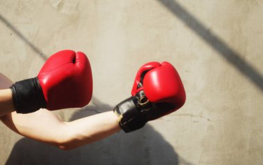 Kırmızı boks eldivenli adam dövüş pozisyonunda duruyor. Spor salonundaki spor aktiviteleri. Somut bir geçmiş. Boşluğu kopyala