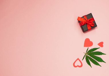 Sevgililer günü afişi. Kenevir yaprağı düz yerde yatıyordu. Kalp şeklinde. Sevgililer için marihuana hediyesi. Uzayı kopyala Romantik duvar kağıdı. Dikey yönelim 