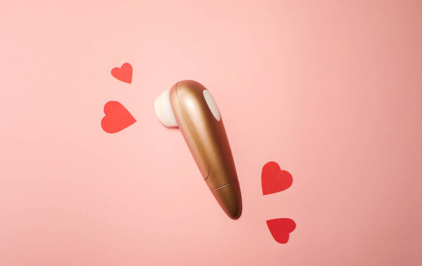 Woman vibrator flat lay. Valentines day. Sex toys wallpaper. Pink paper hearts 