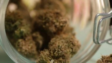 Cam kavanozdan kenevir tomurcuklarını al. Tıbbi marihuana deposu. 