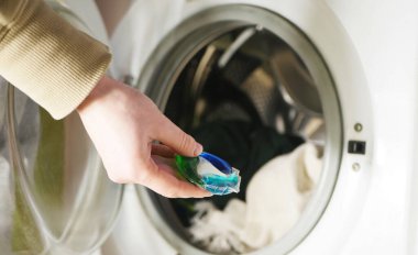 Çamaşır makinesi için el tutuşu jel kapakları. Ev temizlik malzemeleri. Kirli çamaşırların bahar temizliği 