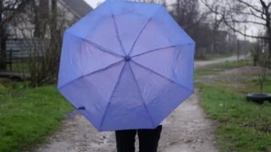Yağmurluklu kadın dışarıda şemsiye değiştiriyor. Yağmurlu bir hava. Eğleniyorum.