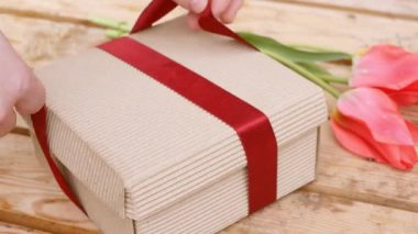 Hediye paketini kapat. Kırmızı kurdeleli paket hediyesi. 4k video