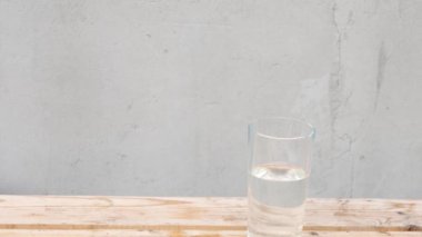 Bir bardak suda tek çiçek. Elinle vazoya pembe lale koy. Ev dekorasyonu. Boşluğu kopyala