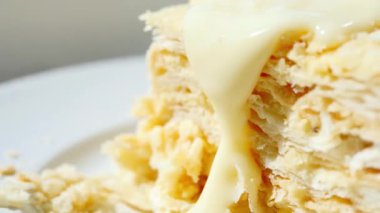 Close up melted white chocolate pouring on cake. Details of tasty sweets. 4k food video.