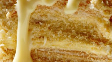 Close up melted white chocolate pouring on cake. Details of tasty sweets. 4k food video.