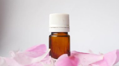 Cam şişe ve esans yağı. Çiçek yaprakları video üfleme. Doğal cilt bakım ürünleri