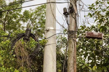 İki direk, bir ahşap ve diğer beton birden fazla kablo ve telekomünikasyon ve kablo hizmetleri bağlantısını destekler.. 