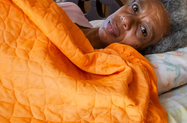 Жінка Рожевому Одязі Покрита Помаранчевою Ковдрою Поширена Ліжку Відкритими Очима Ліцензійні Стокові Фото