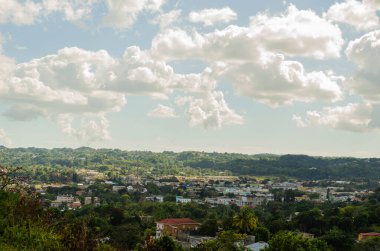 Akşamın güneş ışığı, kalın kabarık bulutların ardından küçük kasabanın üzerine gölge düşürüyor..