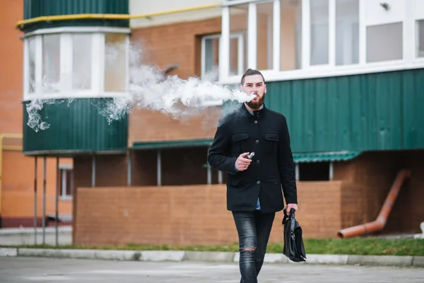 Homem com barba fumar cigarro eletrônico ao ar livre Imagem De Stock