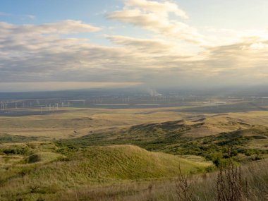 Yel değirmenli manzara. Bir tepenin üzerinde bulunan rüzgar türbini.