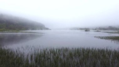 Sabahın erken saatlerinde dağlardaki bir göldeki sislerin hava görüntüleri.