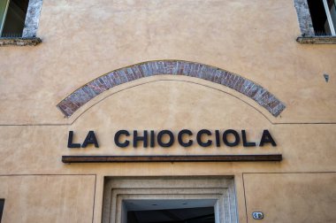 Montepulciano, Italy- 11 Temmuz 2025: Montepulciano 'daki La Chiocciola çocuk giyim mağazasının tabelası