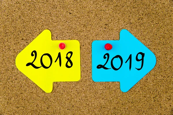 Mensaje 2018 versus 2019 en las notas en papel de flecha —  Fotos de Stock